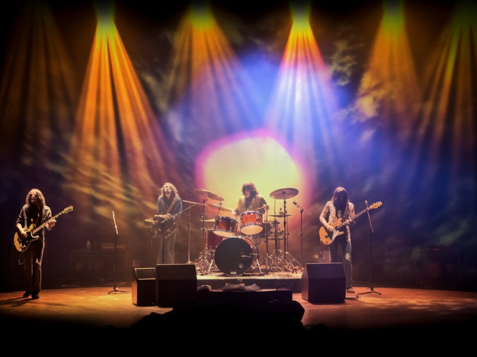 trippy 1970s music scene background with colorful stage lighting and a band on stage